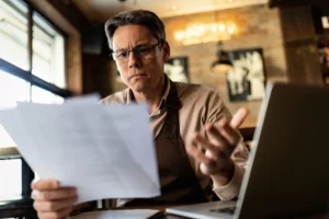 a man at a desk with a look of wonder looking at some papers